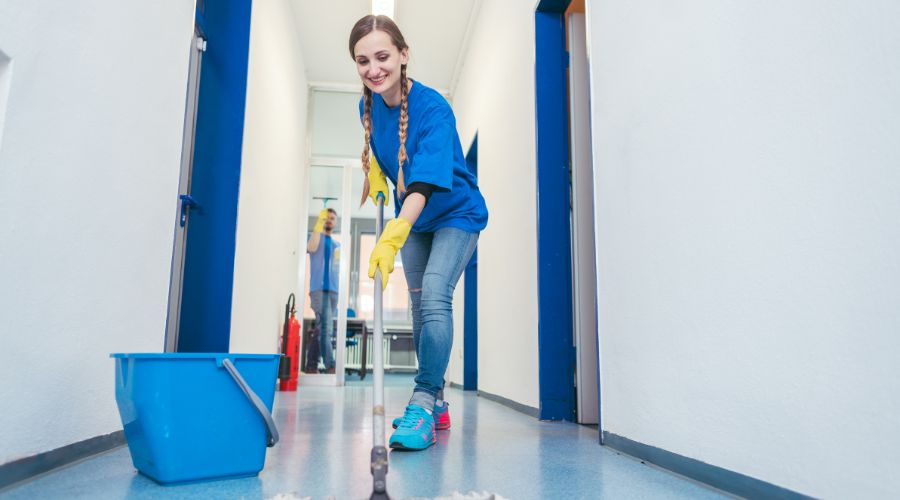 Image showing a cleaning lady that is a remote worker that has clocked in using a mobile phone time clock and has started cleaning floors